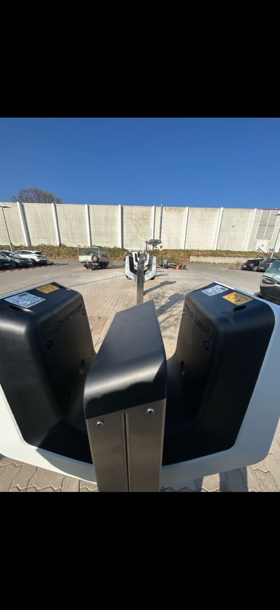 Reihe von fest installierten E-Ladesäulen auf einem großen Firmenparkplatz – professionelle Ladeinfrastruktur für gewerbliche Fuhrparks.